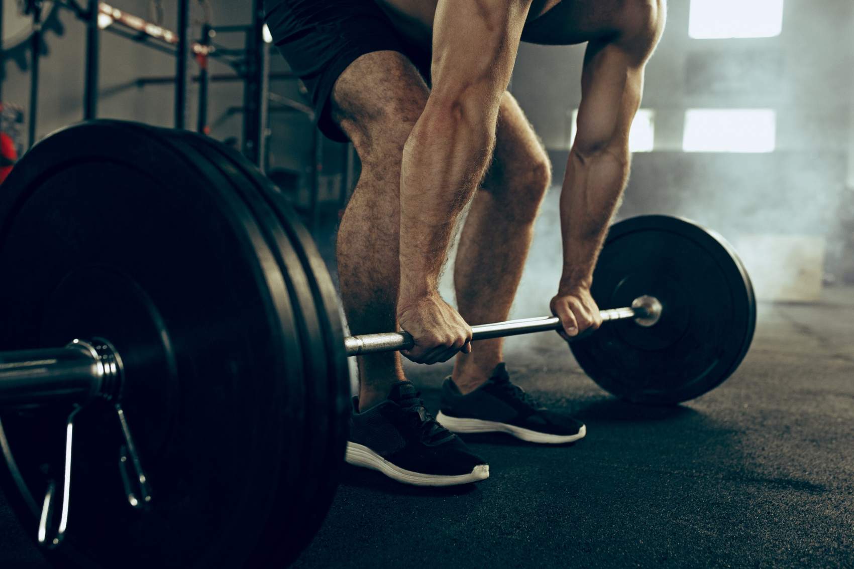 Fit young man lifting weight working out at a gym. Sport, fitness, weightlifting, bodybuilding, training, athlete, workout exercises concept