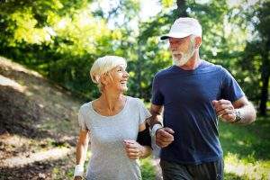 Fitness, sport, people, exercising and lifestyle concept - mature couple running