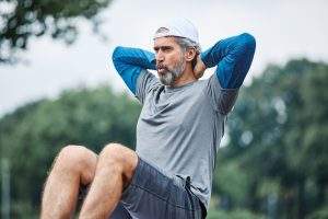 portrait of a senior man exercising and doing crunches